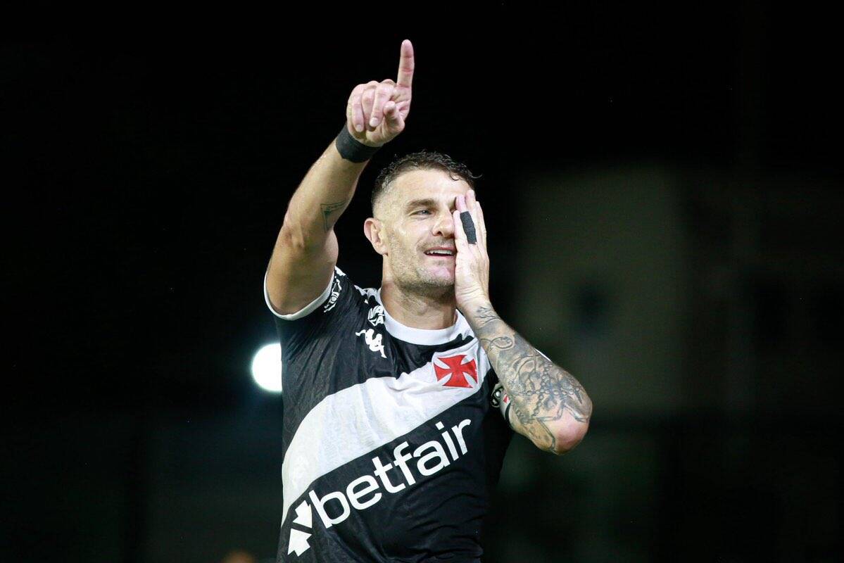 Jogador comemorando com dedo apontado para o alto.