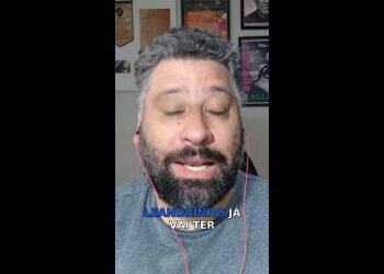 Homem com barba usando fones de ouvido vermelhos.