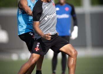 - Jogador treinando futebol com adversário próximo.