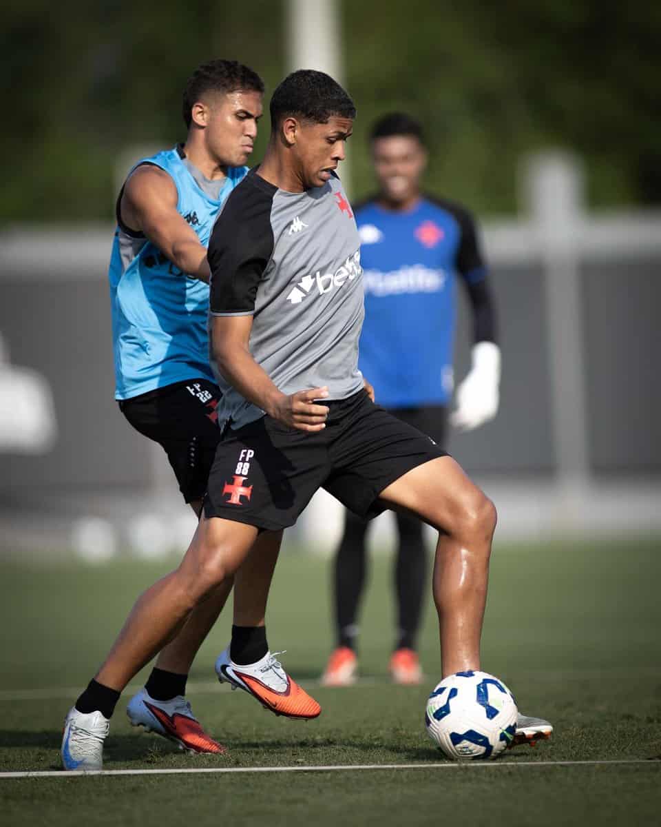 - Jogador treinando futebol com adversário próximo.