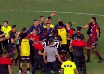 Jogadores do Vasco e árbitro discutindo no campo.