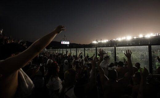 Torcida do Vasco assistindo ao jogo ao pôr do sol.