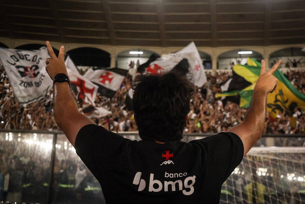 Vasco da Gama torcedor ergue os braços com bandeiras.