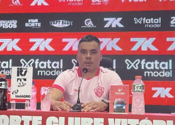 Vasco do Brasil em coletiva de imprensa, homem sentado ao lado de microfone.