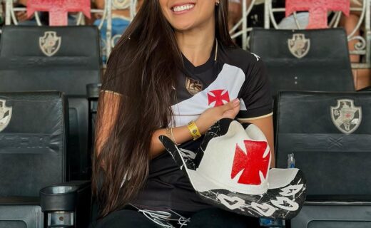 Apostando na paixão pelo Vasco, torcedora sorridente com uniforme do time.