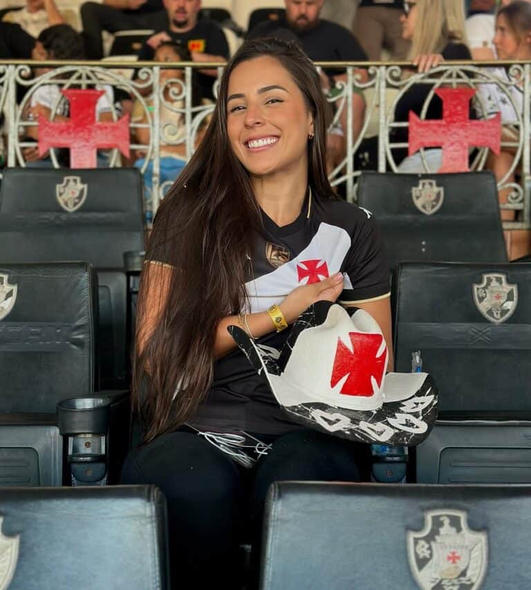 Apostando na paixão pelo Vasco, torcedora sorridente com uniforme do time.