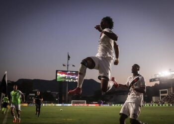 Jogador do Vasco pulando em celebração no estádio.