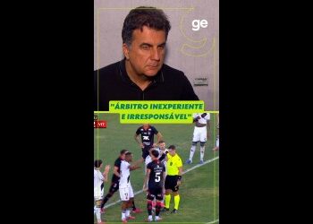 Árbitro em campo durante jogo de futebol.