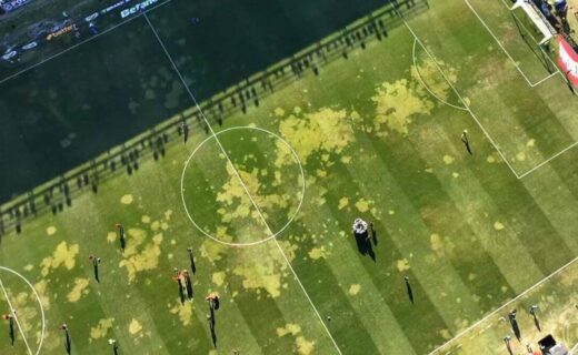 Gramado de futebol com manchas de óleo no campo.