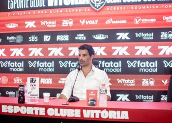 Vasco da Gama em coletiva de imprensa com painel de patrocinadores ao fundo.