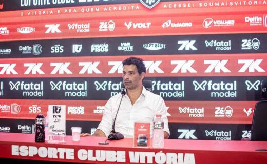 Vasco da Gama em coletiva de imprensa com painel de patrocinadores ao fundo.