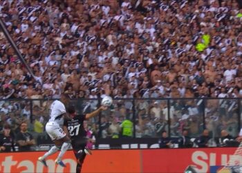 Jogadores disputando a bola durante partida de futebol.