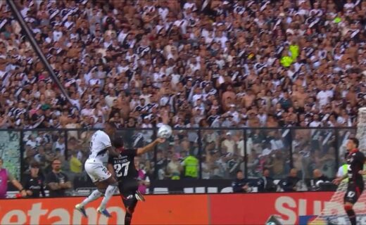Jogadores disputando a bola durante partida de futebol.