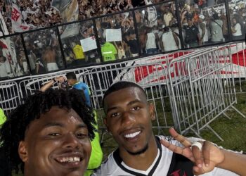 Vasco jogadores comemorando com torcida ao fundo.
