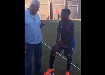 Homem e jogador de futebol conversando.