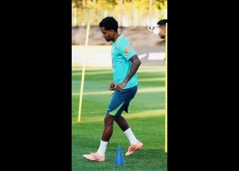 Atleta do Vasco treinando com cones no campo.