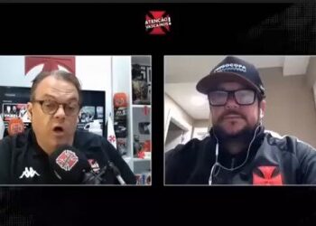 Homens em entrevista, um com microfone Vasco.