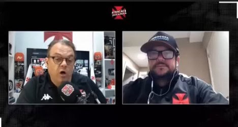 Homens em entrevista, um com microfone Vasco.