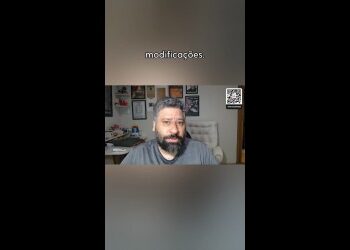 Homem com barba em escritório com quadros.