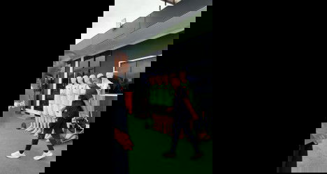 Jogador de futebol na frente de manequins de treino.