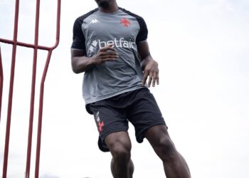Jogador de futebol correndo no campo.