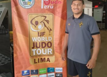 Judo Peru banner and athlete at event.