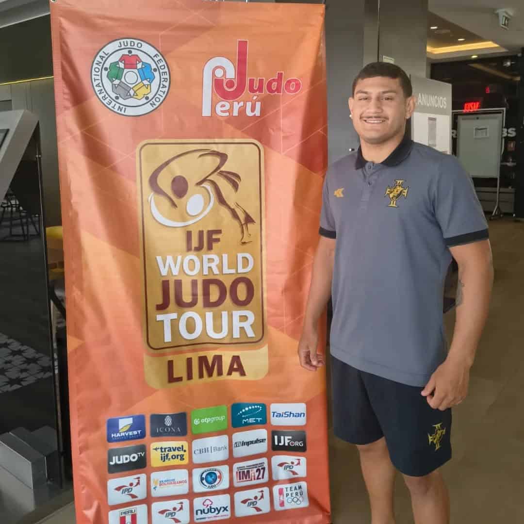 Judo Peru banner and athlete at event.