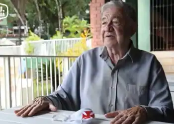 Aposentado conversa ao ar livre.