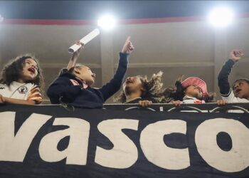 Crianças torcendo com faixas do Vasco.