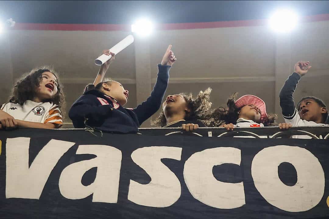 Crianças torcendo com faixas do Vasco.