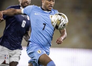 Jogador do Uruguai em ação com a bola durante partida.