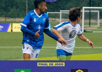 Brasileiro e menino jogando futebol em campo.