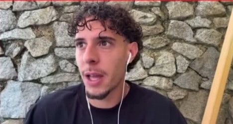 Jovem com cabelo cacheado falando ao celular.