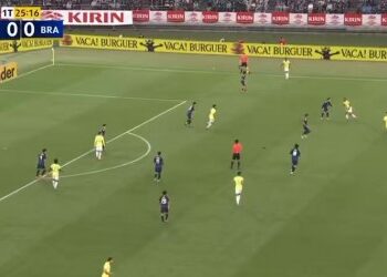 Jogadores em campo durante partida de futebol.