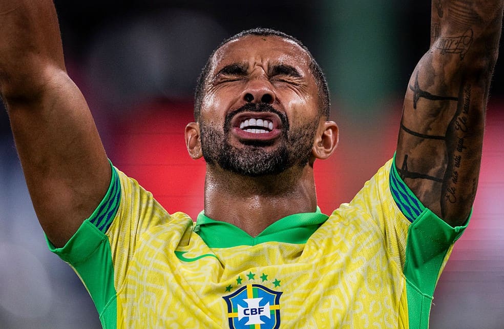 Aterrizado: jogador do Brasil com expressão emotiva, braços levantados, usando uniforme amarelo e verde.