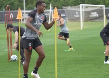 Treinamento de jogadores do Vasco com cones na grama.