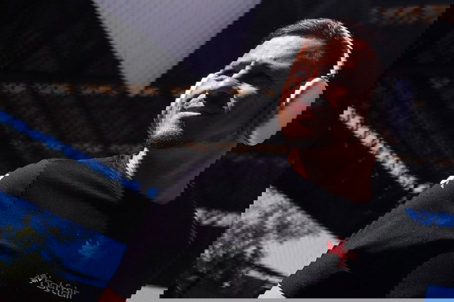 Jogador do Vasco usando fones de ouvido em estádio ao ar livre.