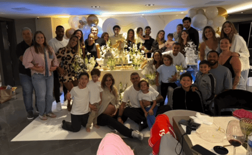 Festa de aniversário com muitas pessoas sorrindo e decoração elegante.