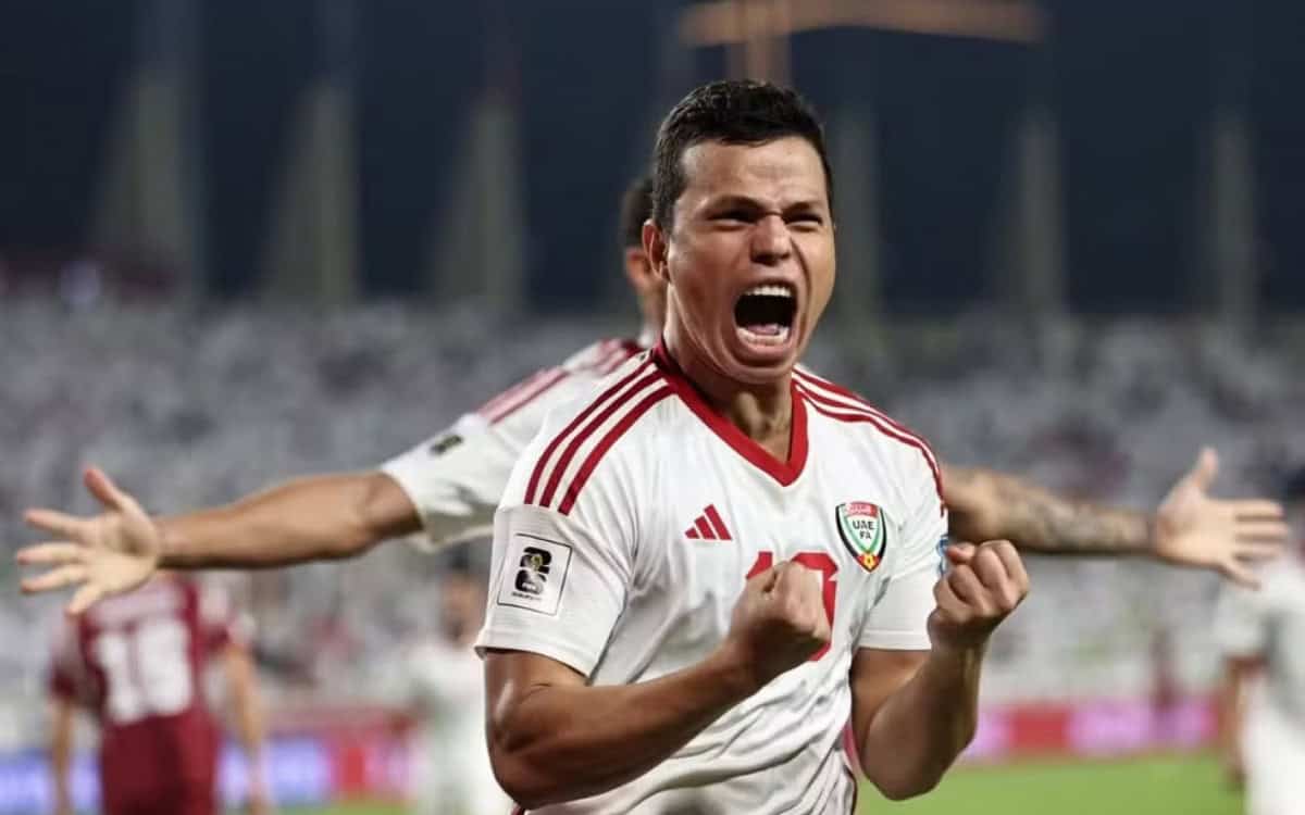 Jogador comemorando com entusiasmo em campo de futebol.