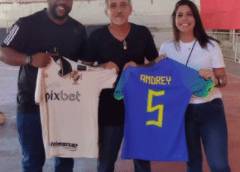 Mario Andrey e duas pessoas segurando camisas de futebol do Vasco.