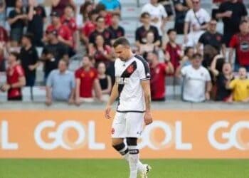 Jogador do Vasco de cabeça baixa em campo.
