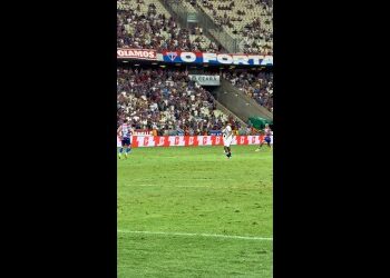 Jogadores em campo durante partida de futebol.
