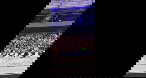 Torcida do Vasco em estádio; fãs vibrando.