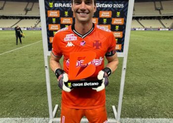 Jogador comemorando vitória com troféu do Vasco.