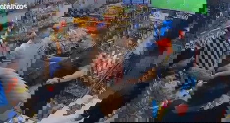 Homens discutindo na loja; loja com produtos diversos.