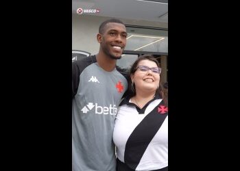 Jogador do Vasco com torcedora sorridente.