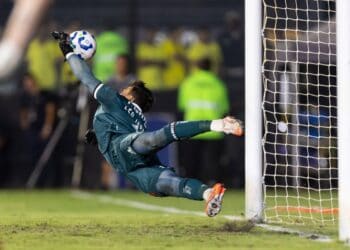 Salto do goleiro do Vasco defendendo chute ao gol.