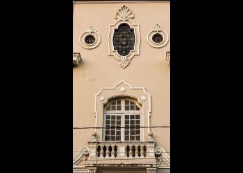 Detalhe de fachada com janela e ornamentos clássicos.