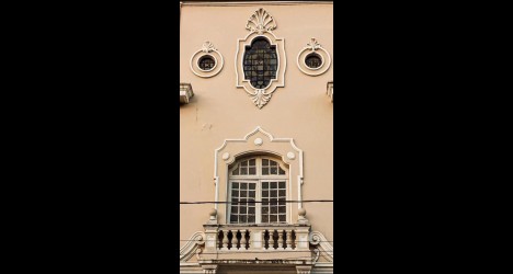 Detalhe de fachada com janela e ornamentos clássicos.