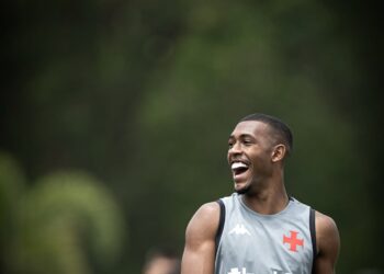 Vasca masculino sorrindo durante treino ao ar livre.